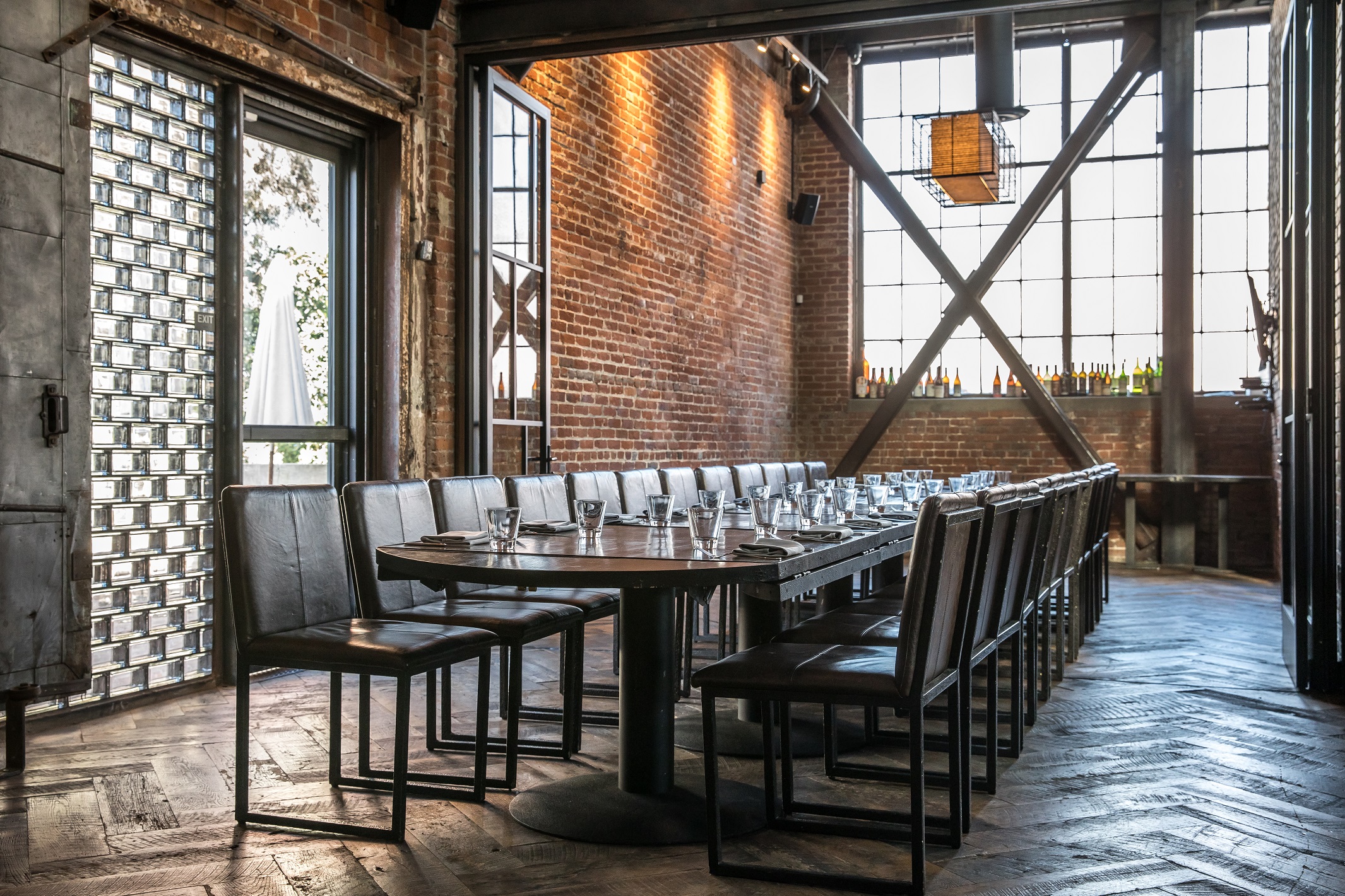 Inside Brera restaurant, industrial style, properly set dining table and comfortable leather chairs waiting to receive guests